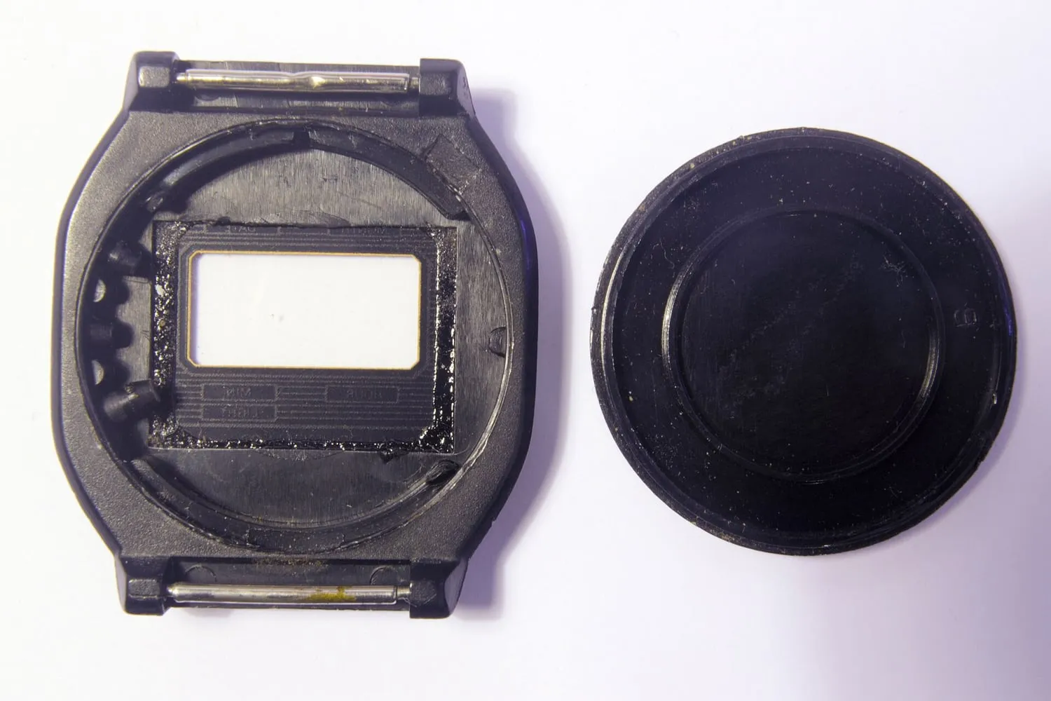 The back of a watch case opened to show the movement inside