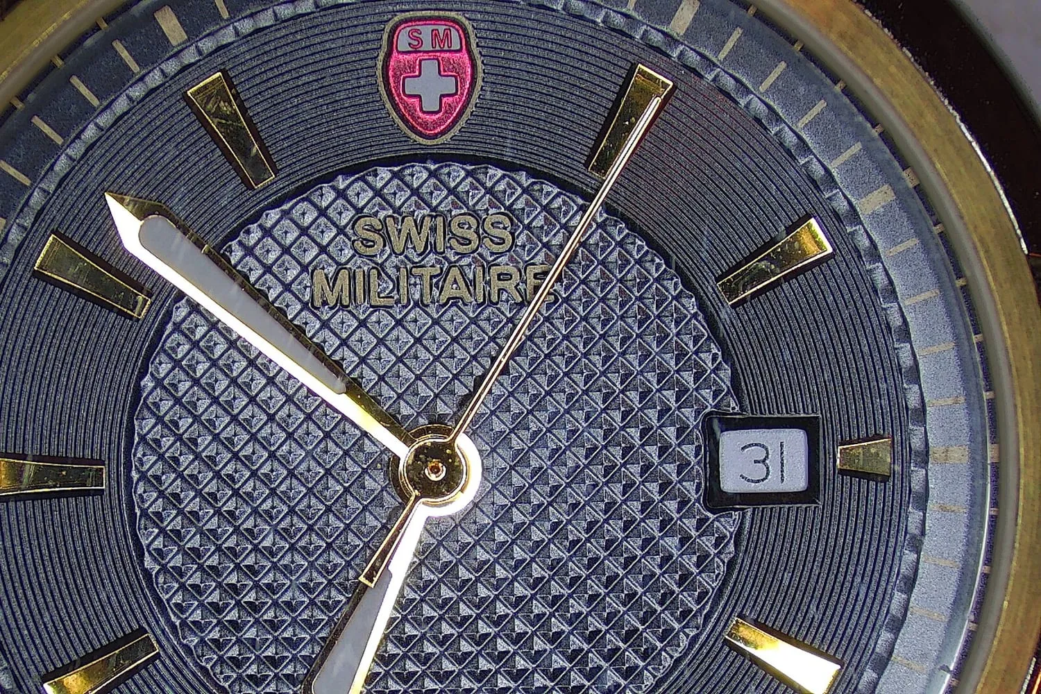 A watch dial with hour markers and hands shown in close detail